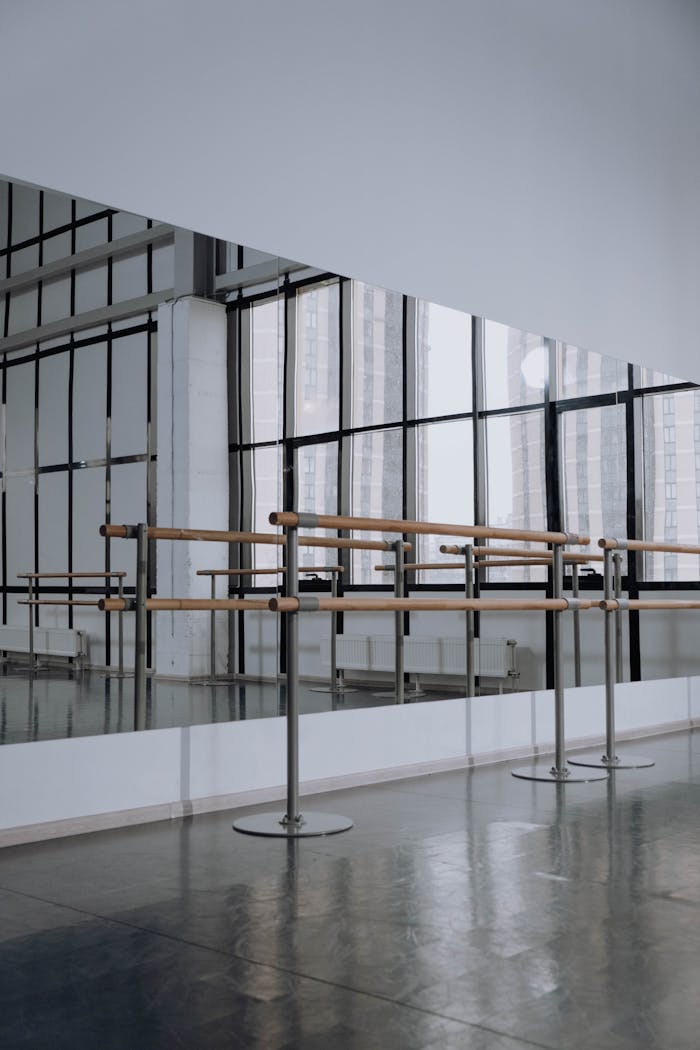 Modern ballet studio featuring mirrored walls and ballet barres, perfect for dance practice.